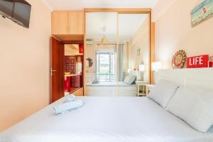 1 Schlafzimmer mit einem weißen Bett und einem Badezimmer in der Unterkunft Athens Strawberry Hideaway - City Chic Retreat in Athen