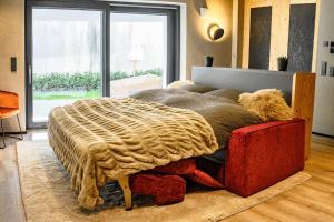 ein Schlafzimmer mit einem Bett mit einer Decke darauf in der Unterkunft Luxuriöse Ferienwohnung Seelage in Friedrichshafen