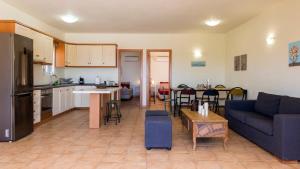 a living room with a blue couch and a kitchen at Seaside Aqua Bliss & Serenity with Private Pool in Koilás +38 photos