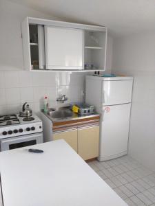 a kitchen with a white refrigerator and a sink at Apartment Bugenvila in Vrboska