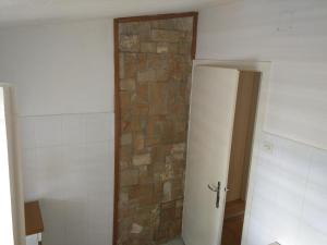 a bathroom with a brick wall next to a door at Apartment Bugenvila in Vrboska