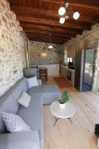 a living room with a gray couch and a table at Malia Stone Residence - Secluded Cozy Retreat in Goníai