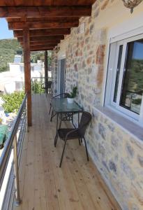 a patio with a table and chairs on a balcony at Malia Stone Residence - Secluded Cozy Retreat in Goníai
