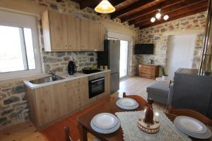 a kitchen with wooden cabinets and a table with a table sidx sidx sidx at Malia Stone Residence - Secluded Cozy Retreat in Goníai +11 photos