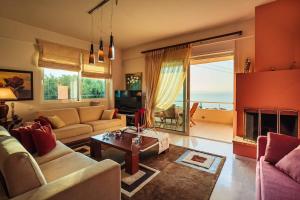 a living room with a couch and a fireplace at Verga Sunset Villa - Ilia Seascape Private Retreat in Mikrá Mandínia