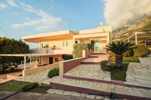 a house with a stone walkway in front of it at Verga Sunset Villa - Ilia Seascape Private Retreat in Mikrá Mandínia