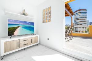 un salon avec une grande télévision murale à écran plat dans l'établissement Penthouse Ancla 561 Levante Beach, à Benidorm