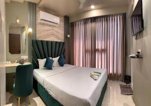 a hotel room with a large bed and a desk at Hotel Grand Nidhivan in Nagpur