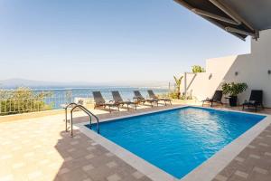 The swimming pool at or close to Aigli Luxury Villa - Seaview Panoramic Retreat