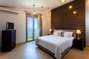 A bed or beds in a room at Aigli Luxury Villa - Seaview Panoramic Retreat