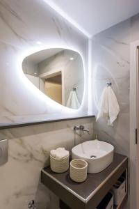a bathroom with a sink and a mirror at Kalamata Aigli Lux Seafront Retreats- Up to 11ppl in Kalamata