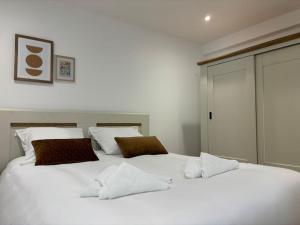 ein weißes Bett mit zwei Kissen darüber in der Unterkunft La Tournelle in Langres
