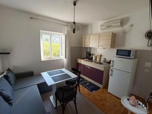 uma pequena cozinha com uma mesa e um frigorífico em Apartman Ena em Senj