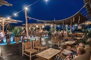 a group of people sitting at a restaurant at night at Beach Studio Durrës in Durrës +9 photos