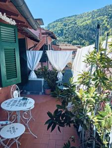 une terrasse avec des tables et des chaises dans une maison dans l'établissement La terrazza di Ameglia alta - relax nel borgo Ligure, à Ameglia