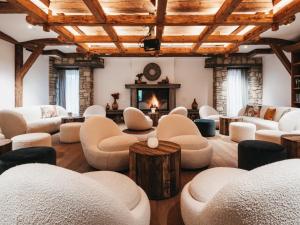 a room with chairs and tables and a fireplace at Hotel Oberforsthof in Sankt Johann im Pongau