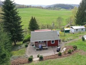 an aerial view of a red house with a person sitting on a porch at Ferienhaus Schneekopf in Suhl