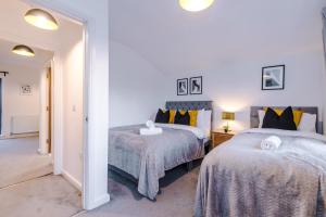 Schlafzimmer mit 2 Betten und Flur in der Unterkunft Beautiful Manchester Home Sleeps 9 by PureStay Short Lets in Manchester