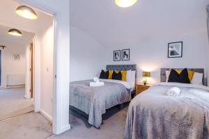 a bedroom with two beds and a hallway at Stunning Manchester House Sleeps 10 with Parking by PureStay - Short Stays & Accommodation in Manchester