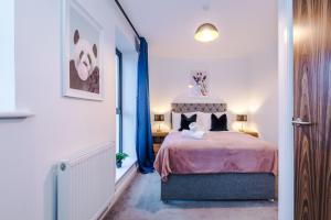 a bedroom with a bed and a window with blue curtains at Stunning Manchester House Sleeps 10 with Parking by PureStay - Short Stays & Accommodation in Manchester