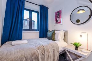 a bedroom with a bed and a window with blue curtains at Beautiful Manchester Home Sleeps 9 by PureStay Short Lets in Manchester