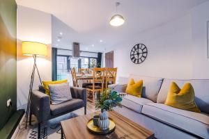 a living room with a blue couch and yellow pillows at Beautiful Manchester Home Sleeps 9 by PureStay Short Lets in Manchester
