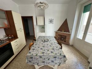une cuisine avec une table et une cuisine avec une cheminée dans l'établissement Dimora storica fronte mare con terrazzo privato, à Torre Canne