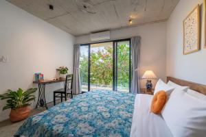 a bedroom with a bed and a desk and a window at Min's House Hoi An - 4 bedroom villa, pool in Hoi An