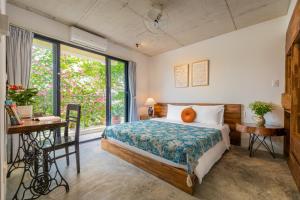 a bedroom with a bed and a desk and a window at Min's House Hoi An - 4 bedroom villa, pool in Hoi An