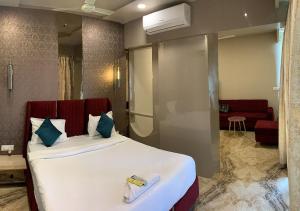 a bedroom with a large bed and a living room at Hotel Grand Nidhivan in Nagpur +24 photos