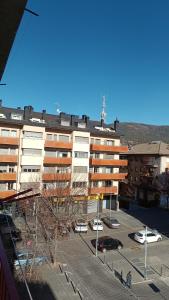 un gran edificio con un estacionamiento delante de él en Apartamento confort I, en La Seu d'Urgell