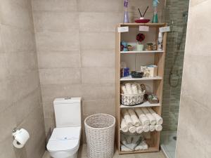 a bathroom with a toilet and a shelf with towels at Apartamento confort I in La Seu d'Urgell +34 photos