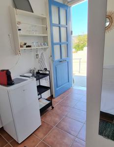 eine Küche mit blauer Tür und Fliesenboden in der Unterkunft Panoramic View apartment in Poros