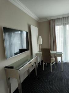 a hotel room with a desk and a large mirror at Hotel & Restaurant Schönau in Peine