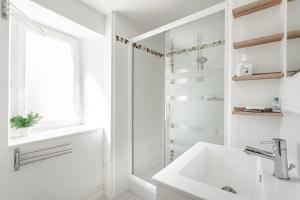 biała łazienka z umywalką i prysznicem w obiekcie Apart Sud Vendée,zen et confort w mieście Saint-Hilaire-des-Loges