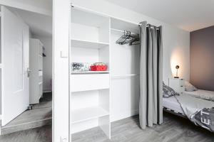 sypialnia z białymi półkami i łóżkiem w obiekcie Apart Sud Vendée,zen et confort w mieście Saint-Hilaire-des-Loges