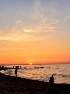 a person sitting on the beach watching the sunset at Baltic Line Marina-Mewa in Gdańsk