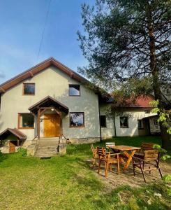 a house with a picnic table in front of it at Dom wśród Sosen in Rzędkowice