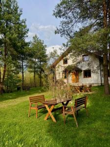 a picnic table and bench in front of a house at Dom wśród Sosen in Rzędkowice