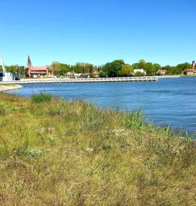 a bridge over a river with a grassy field at Baltic Line Marina-Mewa in Gdańsk