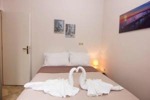 two white swans sitting on top of a bed at Selinitsa Stone Home - Mani's Private Pool Retreat in Agios Nikolaos