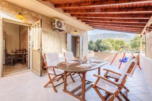 a dining room with a table and chairs on a patio at Selinitsa Stone Residence-Private Poolside Retreat in Agios Nikolaos
