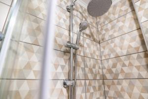 a shower in a bathroom with tiled walls at Paralion Town Apartments in Alexandroupoli +87 photos