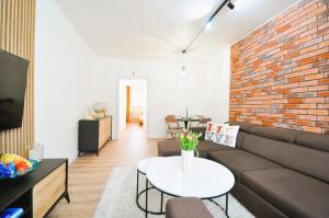 a living room with a couch and a brick wall at Apartment Fragrantly in Poprad