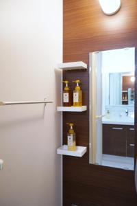 two bottles of honey sitting on shelves in a bathroom at The Peak Chiyozaki in Osaka