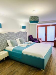 a bedroom with a large bed and a chair at Kumsal Butik Otel in Istanbul