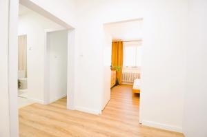 Habitación vacía con paredes blancas y suelo de madera. en Apartment Fragrantly, en Poprad