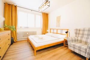 a bedroom with a bed and a chair and a window at Apartment Fragrantly in Poprad
