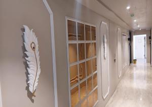 a hallway with a wall with a shelf with glasses at Hotel Grand Nidhivan in Nagpur