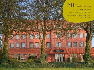 een rood bakstenen gebouw met bomen ervoor bij Classik Hotel Magdeburg in Maagdenburg